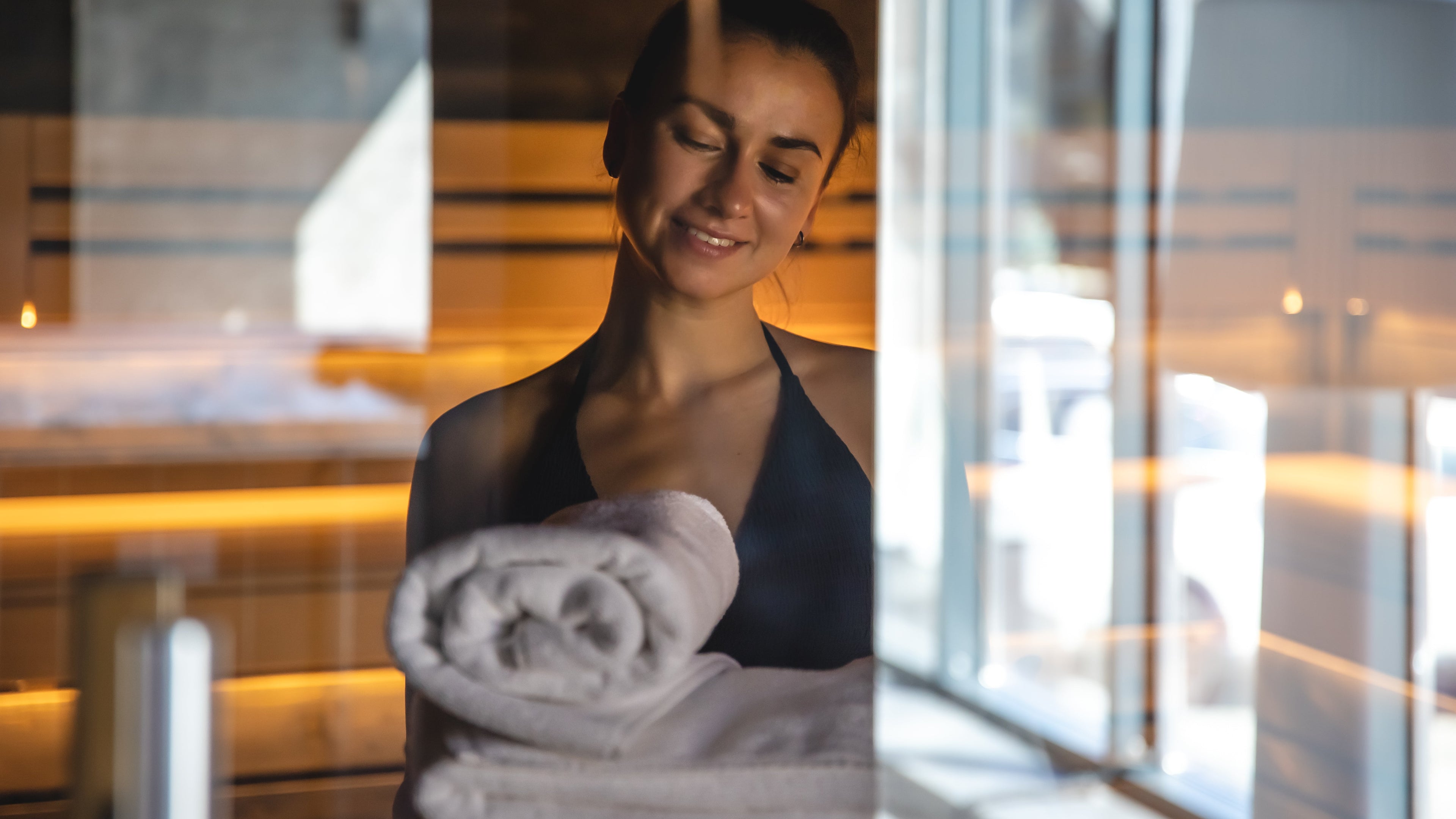 women in  sauna holding towel 